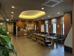 a waiting room with chairs and a large yellow ceiling at Hotel Route-Inn Mooka in Mooka