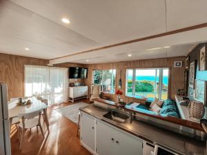 a kitchen and living room with a couch and a table at Patons Rock Cutie in Rangihaeata