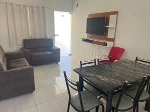 a living room with a table and a couch at Residencial Villa dos Corais - Staybeach in Porto Seguro