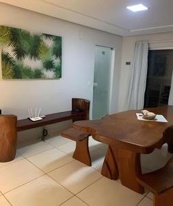 a dining room with a wooden table and chairs at Residencial Villa dos Corais - Staybeach in Porto Seguro