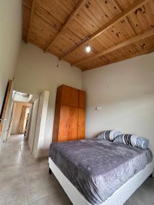 a bedroom with a bed and a wooden ceiling at Cabaña en cañuelas in Cañuelas