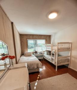 a bedroom with two beds and a crib at Patons Rock Cutie in Rangihaeata