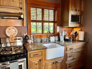 a kitchen with a sink and a stove at Beach Kayaks Hot Tub Private Cottage in Friday Harbor