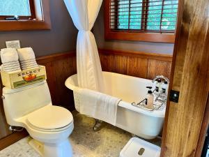 a bathroom with a tub and a toilet and a sink at Beach Kayaks Hot Tub Private Cottage in Friday Harbor +14 photos