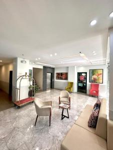 a lobby with couches and chairs in a building at Ace Penzionne by Hiverooms in Pajo