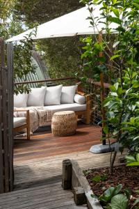 a wooden deck with a couch under a canopy at Surf Haven in Lorne