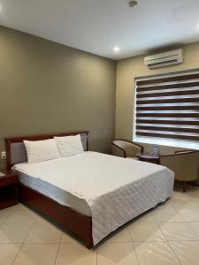 a bedroom with a large bed and a window at Nam Phong Hotel & Coffee in Cái Rồng