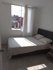 a bed in a room with a window at departamento familiar privado trujillo huanchaco in Huanchaco