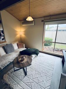 a bedroom with a bed and a table and a window at Hannahs Haven in Traralgon