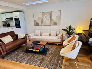 a living room with a couch and a table at Pine Cabin Right A Short Stroll to Zig Zag Railway in Clarence