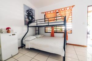 a bedroom with a bunk bed in a room at Santa Toro Inn, private rooms close to the beach in Santa Teresa Beach