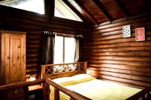 a bedroom with a bed in a log cabin at Gasty Ranch in Mar del Plata