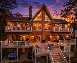 a large house with a wrap around deck at sunset at Ultimate LKA Retreat Boatdock Heated Pool Hottub in Mineral