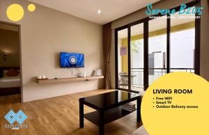 a living room with a table and a tv at Harmony Serene 3BR Nomad Sematan Beach Resort in Sematan