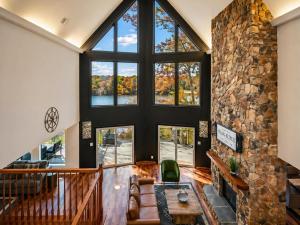 a living room with a large window and a stone wall at Ultimate LKA Retreat Boatdock Heated Pool Hottub in Mineral