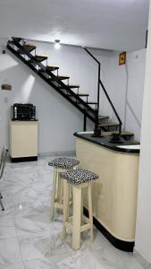 eine Theke mit zwei Hockern und eine Treppe in einem Zimmer in der Unterkunft ApartWestern in Chilecito