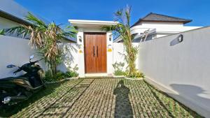 a scooter parked in front of a house with a door at Casa Anagata Pandawa in Ungasan