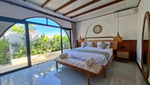 a bedroom with a large bed and a swimming pool at Casa Anagata Pandawa in Ungasan +18 photos