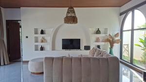a living room with a couch and a tv at Casa Anagata Pandawa in Ungasan