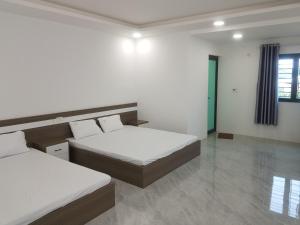 a bedroom with two beds and a window at Nhà nghỉ My Home in Mộc Châu