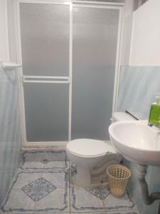 a bathroom with a toilet and a sink at Departamentos La Frontera in Tulcán +13 photos