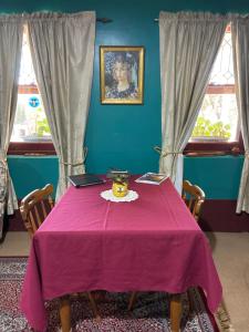 a table with a purple table cloth on it with two windows at Bethany Cottages in Bethany +21 photos