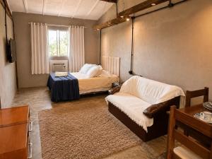 a living room with two beds and a couch at Refúgio Pauapique - Suítes com café da manhã, ar condicionado e frigobar à 900 metros da Rota do Vinho in São Roque +100 photos