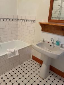 a bathroom with a sink and a bath tub at Bethany Cottages in Bethany