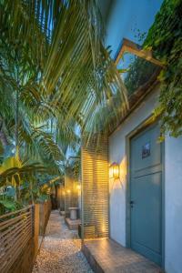 a house with a hallway with palm trees at Studio O - Two-Floor Studio, Walk to the Beach in Seminyak
