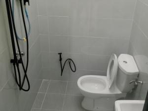a bathroom with a shower with a toilet and a sink at Homestay Adilah A in Pasir Puteh +32 photos