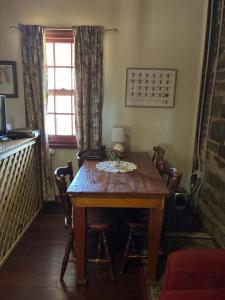 a dining room table with chairs and a window at Bethany Cottages in Bethany