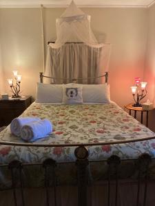 a bed with two towels sitting on top of it at Bethany Cottages in Bethany