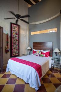 a bedroom with a large bed and a ceiling fan at Historical Green House Campeche in Campeche