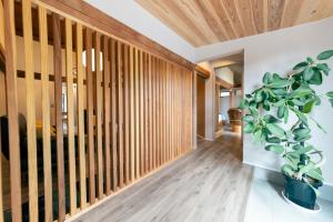 a hallway with wooden walls and a potted plant at atsumaro in Minamiboso