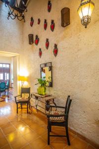 a living room with chairs and a wall with decorations at Historical Green House Campeche in Campeche