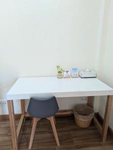 a white desk with a chair in a room at Cozy Shell in General Luna