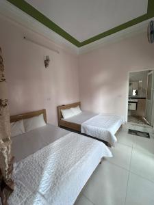 a bedroom with two beds and a mirror at Khách sạn Hùng Thảo in Sầm Sơn