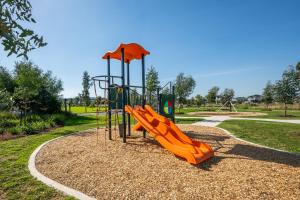 a playground with an orange slide in a park at Greenview Place - Officer in Officer