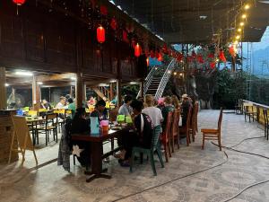 a group of people sitting at tables in a restaurant at Rocky Eco House in Na Hang