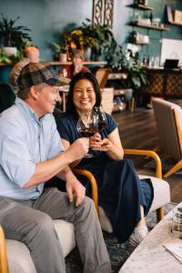 a man and a woman holding a glass of wine at The Dundee - A Trace Hotel in Dundee