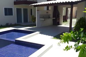 a swimming pool in front of a house at Residencial Villa dos Corais - Staybeach in Porto Seguro