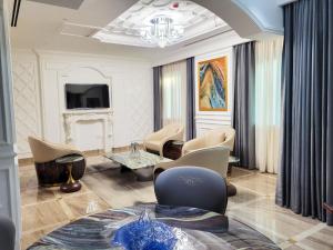a living room with chairs and a chandelier at Fountain Palace Hotel & Suites in Kampala