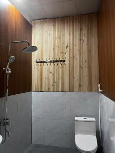 a bathroom with a toilet and a wooden wall at Rocky Eco House in Na Hang +23 photos
