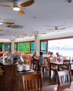 a group of people sitting at tables in a restaurant at Siam Triangle Hotel Chiang Sean in Chiang Saen