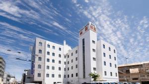 a white building with a sky in the background at Business Hotel Hayashiso in Miyazaki