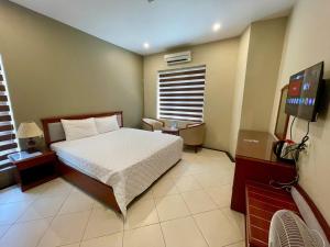 a bedroom with a bed and a flat screen tv at Nam Phong Hotel & Coffee in Cái Rồng