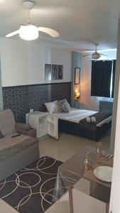 a bedroom with a bed and a living room with a couch at Studio Premium Trianon Centro in Campos dos Goytacazes