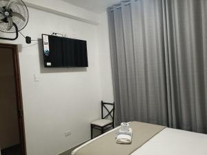 a bedroom with a bed and a tv on the wall at HOUSSE 69 Café Bar in Satipo +22 photos