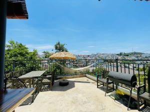 a patio with a hammock and tables and a view at LENA Home in Da Lat
