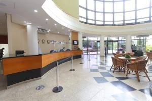 a lobby with a reception desk and tables and chairs at Tropical Executive Hotel 804 - Propriedade Particular in Manaus +17 photos